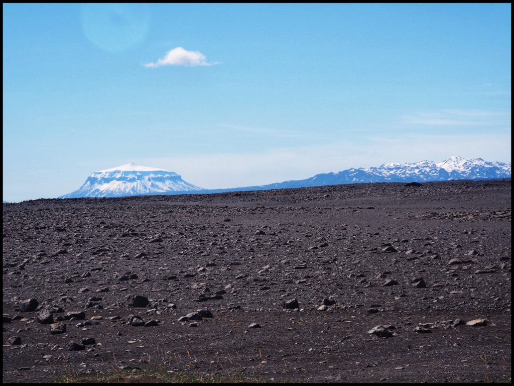 Snow covered mountains and rocks foreground