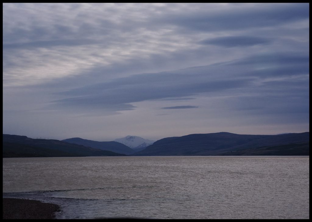 Lake with snow covered mountain in background